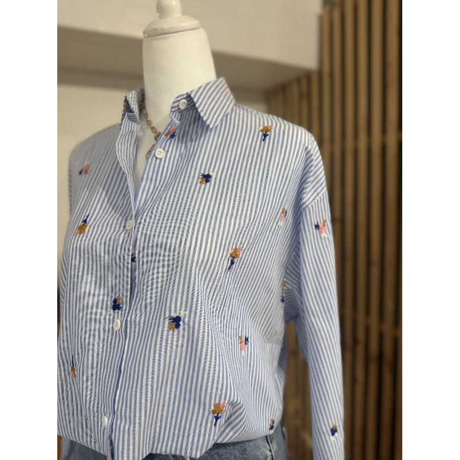 Chemise rayée femme bleu et blanc avec broderies florales colorées.
