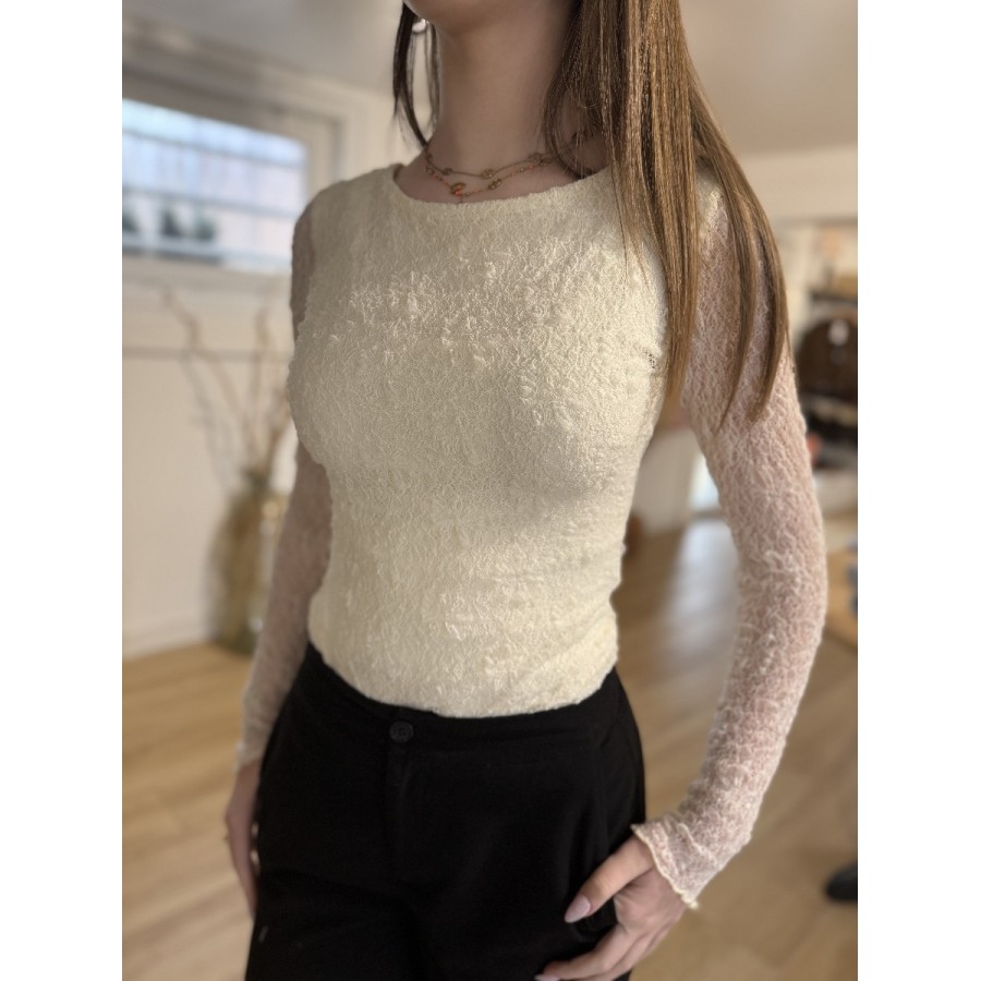 Femme portant un body en dentelle ajusté de couleur écru à manches longues et col bateau